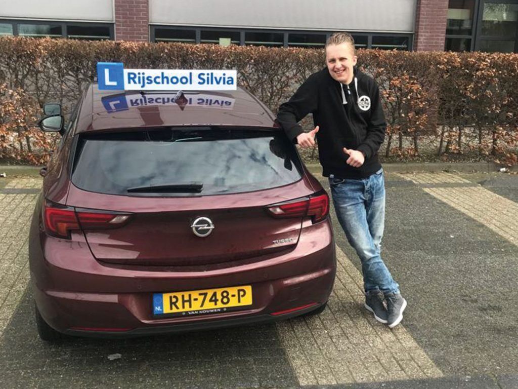 Geslaagde leerling bij de lesauto van Rijschool Silvia