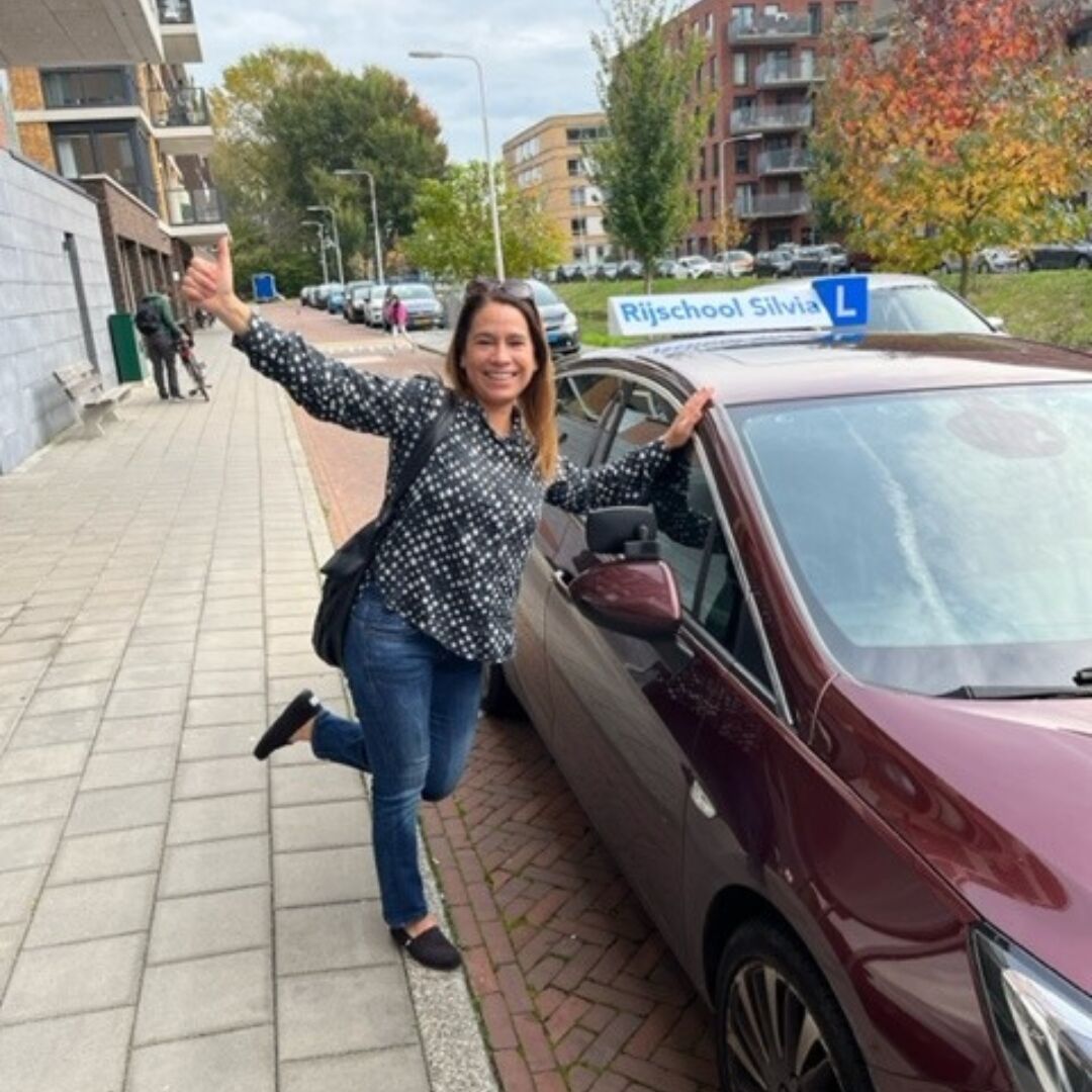Geslaagde leerling bij de lesauto van Rijschool Silvia
